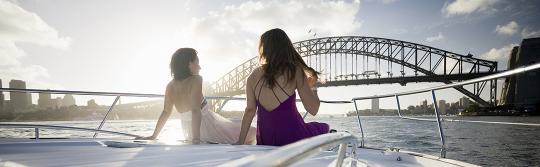 坐在航行於雪梨海港遊艇前部的兩位女士